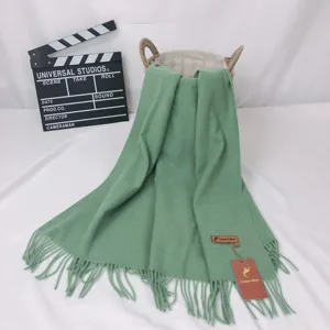Green cashmere blend fringe scarf detail view, soft texture warm winter neck accessory.