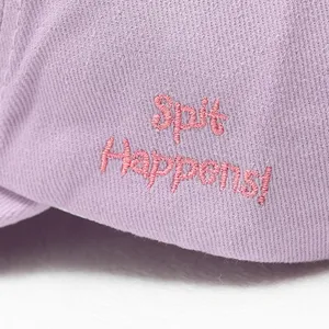 Detailed view of casual purple baseball cap with cute pink embroidered text design.