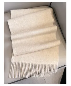 Detailed view of a solid color wool winter scarf with fringes, soft texture and warm design.