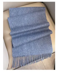 Detailed close-up view of a soft blue wool winter scarf featuring delicate fringe, folded neatly.