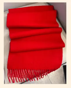 Red wool winter scarf detail shot, cozy fringed texture and warm design for cold days
