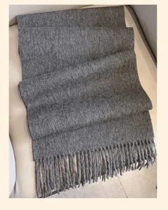 Detailed view of a dark gray woolen scarf featuring classic fringe edges, soft winter texture.