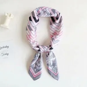 Detailed close-up view of the pink and grey geometric printed silk scarf, showing knots.