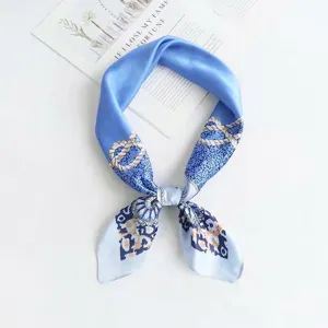 Close-up detail of blue silk square scarf with elegant rope chain leopard print pattern.