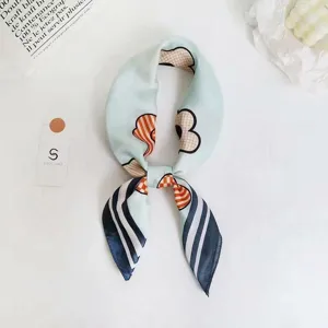 Detailed shot of light blue silk scarf with abstract pattern, elegant neckerchief knot.
