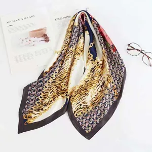 Detailed view of luxury chain and leopard print square silk scarf, soft fabric texture.