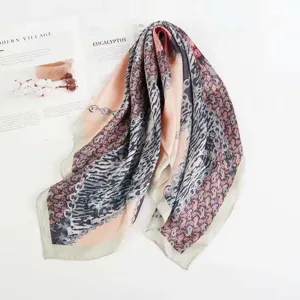 Silk scarf detail shot featuring elegant chain and paisley print, perfect for professional wear.