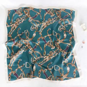 Close-up of elegant square silk scarf with classic teal and gold chain equestrian pattern.