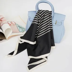 Detailed view of the black and white striped silk square scarf styled with a light blue bag.