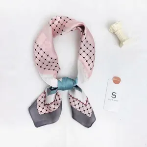 Detailed view of a stylish pink and grey geometric patterned silk scarf with chic design.