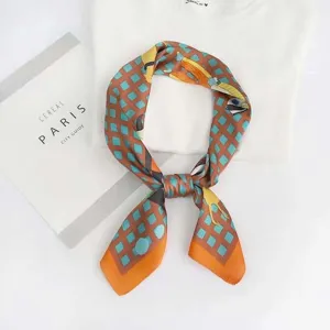 Detailed view of a stylish blue and brown geometric plaid square silk scarf used as neckwear.