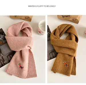 Close-up detail of cozy knitted winter scarf with cute pony embroidery, soft warm fabric.
