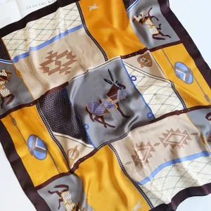 Detail shot of imitation silk square scarf showing classic equestrian and geometric patterns.