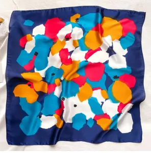 Detailed view of women blue square scarf with vibrant abstract floral print, smooth silk-like fabric.
