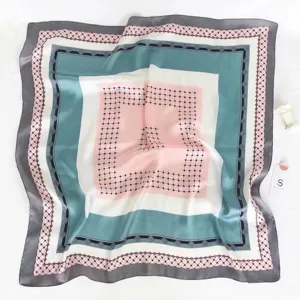 Silk scarf detail showcasing geometric print, pink teal grey border, elegant accessory texture.