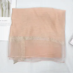 Detailed view of lightweight silk blend scarf with elegant metallic gold trim for women.