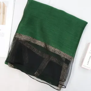 Detailed view of the dark green scarf with stylish gold glitter stripes and black mesh.