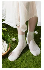 Nahaufnahme Detail von kurzen Mesh-Damen-Socken in Weiß auf grünem Rasenhintergrund Szene.
