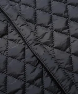 Detailansicht des schwarzen gesteppten Stoffes mit Rautenmuster, feine Nähte und Textur.