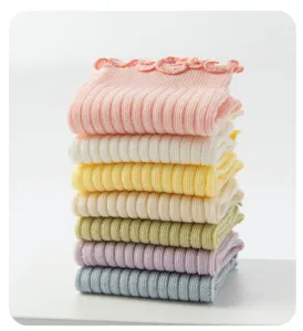 Nahaufnahme des Stapels bunter Kinderrippsocken mit niedlichem Rüschenbesatzdesign.