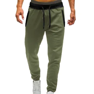 Close-up detail of casual green sweatpants featuring a black elastic waistband and drawstrings.
