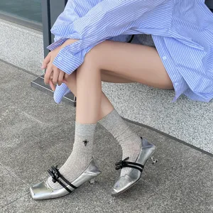 Damen Feinstrumpf Socken mit süßer Stickerei kombiniert mit stylischen metallic silbernen Schuhen.