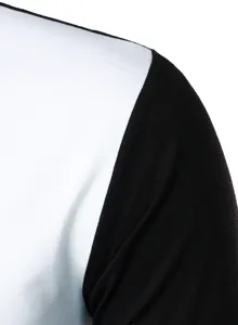 Close-up fabric detail of black and white color-blocked long sleeve top shoulder.