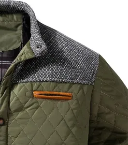 Detailed view of men's quilted jacket with knit contrast shoulder and stylish pocket.