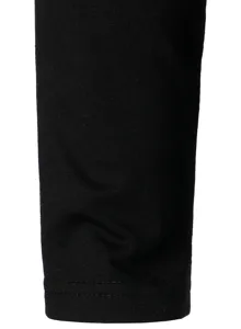 Close-up detail shot of black long sleeve top cuff, showing neat stitching and soft fabric.