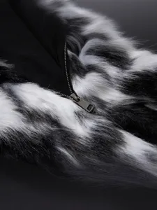 Heren zwart-witte nepbont winterjas close-up met zachte pluche textuur en metalen ritsdetail.