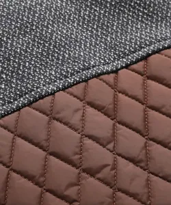 Nahaufnahme des Stoffes einer Herren Steppjacke mit Kontrastnähten und Textur.