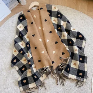 Detailed view of knitted plaid scarf with cute heart patterns and stylish fringe tassels.