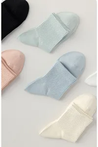 Flat lay detail of breathable cotton mesh solid color short socks in various soft pastel shades.