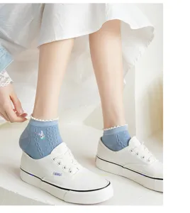 Detailaufnahme von blauen Damenkurzsocken mit süßer Rüschenkante und Hasenstickerei.