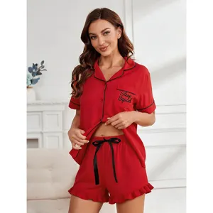 Detailed view of red pajama set featuring black piping, pocket embroidery and cute shorts.