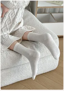 Detailaufnahme weißer Netz-Mustersocken mit strukturierter Strickoptik aus Baumwolle.