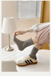 Detailaufnahme grauer Mittelsocken mit niedlicher Hundebestickung im japanischen Trendstil.