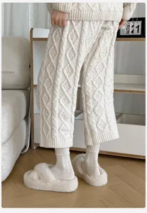Detaillierte Nahaufnahme von kuscheligen Strickhosen, gemusterten Socken und Hausschuhen.