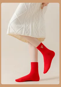 Detailansicht leuchtend roter Socken mit filigraner Goldstickerei und bequemem Rippbündchen.