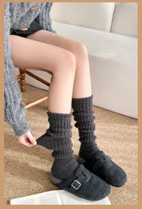 Close-up detail of dark grey knit leg warmers, showing ribbed texture and cozy winter fabric.