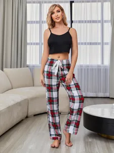 Vista detallada del conjunto de pijama de mujer con parte superior negra y pantalón a cuadros.