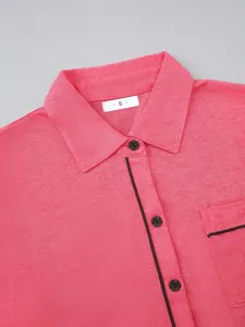 Pink long sleeve pajama top with black piping, lapel collar, and convenient chest pocket.