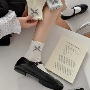 Süße Damen Mittelsocken im College-Stil mit schwarz-weißer Karoschleife und Rüschenrand.