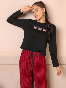 Detailed view of women long sleeve butterfly print top and red check pajama pants sleepwear set.