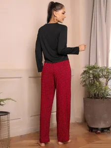 Detail view of women's autumn winter long sleeve top and red plaid pants pajama set.