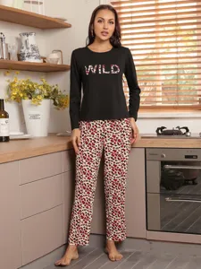 Detailed view of women's long sleeve pajama top and leopard pants home wear outfit.