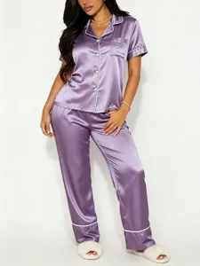 Gedetailleerd overzicht van dames satijn zijde korte pyjama set met elegante witte biesjes.