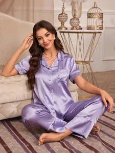 Gedetailleerd shot van een luxe dames satijnen pyjamaset in lichte paars met bies.
