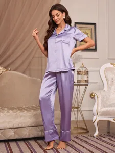 Chique lila satin pyjama detail met korte mouwen top en lange broek in een mooie kamer.