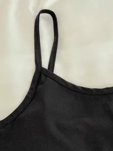 Primer plano del tirante de la camisola negra y escote, tela suave, ropa de dormir cómoda